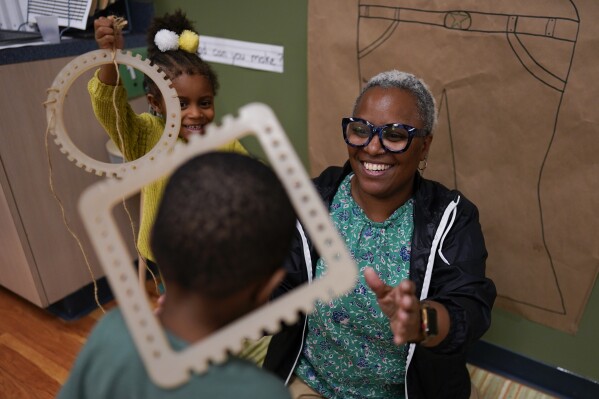 Teacher Dawn Hill works with children during a preschool class at the Life Learning Center - Head Start, in Cincinnati, Tuesday, Nov. 21, 2023. A new plan from the Biden administration could significantly increase salaries for hundreds of low-paid early childhood teachers caring for the country's poorest children but might also force some centers to cut enrollment. (AP Photo/Carolyn Kaster)