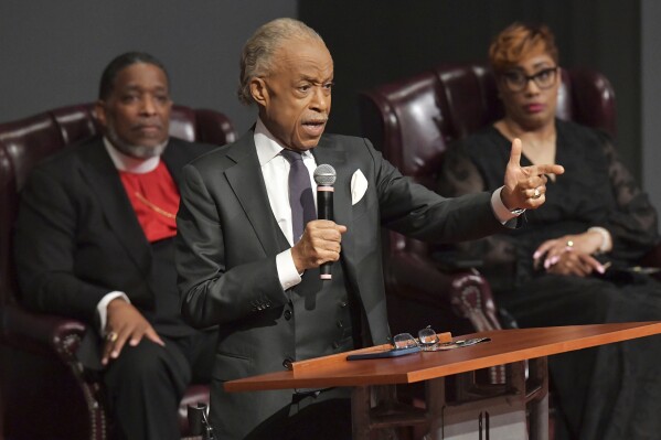 Rev. Al Sharpton addresses the audience as he gives the Eulogy during the memorial service for Dollar General shooting victim Angela Carr, as Bishop Rudolph McKissick, Jr., back, and his wife Pastor Kimberly McKissick, listen during a memorial service at The Bethel Baptist Church, Friday, Sept. 8, 2023, in Jacksonville, Fla. Uber driver Carr was one of three people killed in the racially motivated shooting. (Bob Self/The Florida Times-Union via AP)