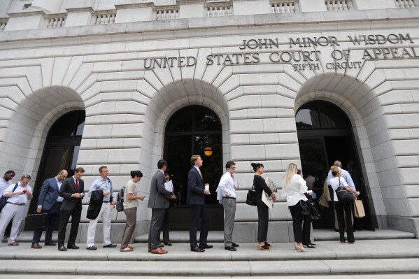 FILE - People wait in line to enter the 5th Circuit Court of Appeals in New Orleans, Jan. 9, 2019. Members of a three-judge panel at the 5th U.S. Circuit Court of Appeals in New Orleans on Tuesday, Nov. 7, 2023, heard an appeal by the Biden administration to a lower court ruling in Texas last year that blocked the use of the government's abortion guidance. (AP Photo/Gerald Herbert, File)