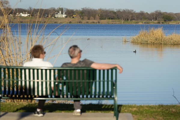 FILE - A couple sit along a trail overlooking White Rock Lake in Dallas on Feb. 24, 2024. Coming up with the best tax strategy in retirement can be much trickier than it seems, and tax pros agree that it is a time when people need to be especially careful. (AP Photo/Tony Gutierrez-File)
