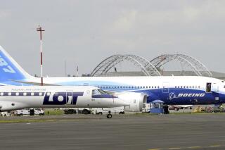 FILE - In this June 24, 2011 photo, a Boeing 787 Dreamliner aircraft standing next to a Polish Airlines LOT plane at the Frederic Chopin airport in Warsaw, Poland. Poland's air travel authorities are warning travelers of possible flight delays and cancellations at Warsaw's airport due to a protest and some flight controllers quitting their jobs. (AP Photo/Alik Keplicz, File)