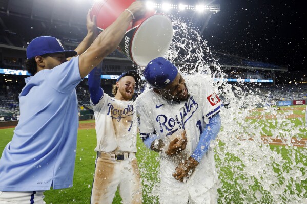 Kansas City Royals' Maikel Garcia, right, is doused by MJ Melendez, left, and Bobby Witt Jr. (7) at the end of a baseball game against the Milwaukee Brewers in Kansas City, Mo., Monday, May 6, 2024. (AP Photo/Colin E. Braley)