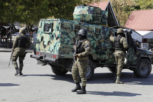 Members of the General Security Unit of the National Palace, USGPN, set up a security perimeter around one of the three downtown stations after police fought off an attack by gangs the day before, in Port-au-Prince, Haiti, Saturday, March 9, 2024. (AP Photo/Odelyn Joseph)