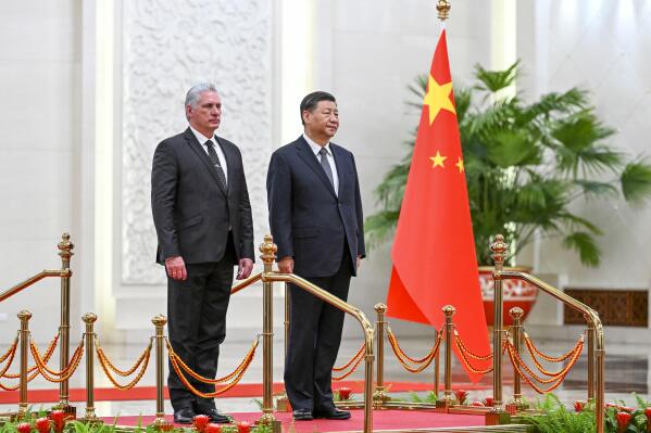 In this photo released by China's Xinhua News Agency, Cuba's President Miguel Diaz-Canel Bermudez, left, and Chinese President Xi Jinping stand during a welcome ceremony at the Great Hall of the People in Beijing, Friday, Nov. 25, 2022. Chinese President Xi Jinping and his Cuban counterpart pledged mutual support over their fellow communist states' "core interests" Friday at a meeting further hailing a return to face-to-face diplomacy by Beijing. (Ding Lin/Xinhua via AP)