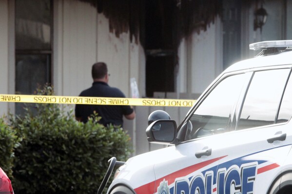 A investigator looks over the fire damaged unit at the Countryside Apartments in Daytona Beach, Fla., Tuesday morning, Nov. 21, 2023. Firefighters responding to an early morning fire in Florida found the body of a woman who had been fatally stabbed, and her three critically injured children. The youngest child was found in a nearby crib and died after being taken to a hospital on Tuesday. Two other children, ages 4 and 5, were being treated at a hospital and their conditions were not immediately known. (David Tucker/The Daytona Beach News-Journal via AP)