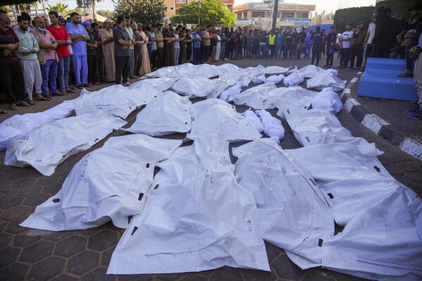 Palestinians mourn relatives killed in the Israeli bombardment of the Gaza Strip in front of the morgue in Deir al Balah, Sunday, Nov. 6, 2023. (AP Photo/Hatem Moussa)