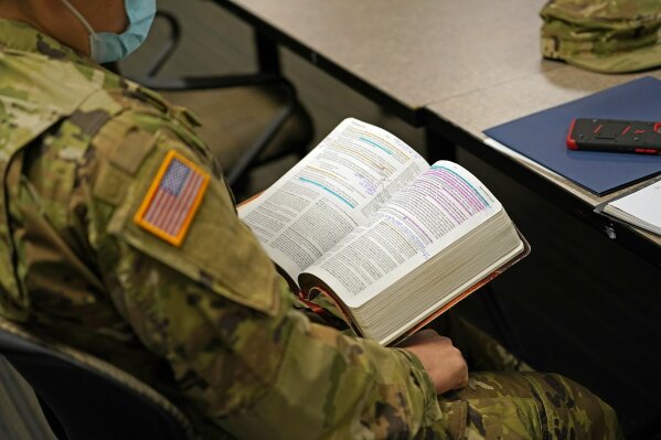 Minnesota National Guard chaplain Charles Kim, a pastor at Korean Presbyterian Church, holds his Bible during a time of devotion for fellow chaplains Oct. 19, 2020 in St. Paul, Minn.  The role of faith leaders who serve as National Guard chaplains has grown more crucial, and more challenging, as thousands of soldiers and airmen, most of them in their 20s, have been increasingly deployed not only in long-lasting overseas wars but in civil unrest across a deeply polarized United States. (AP Photo/Jim Mone)