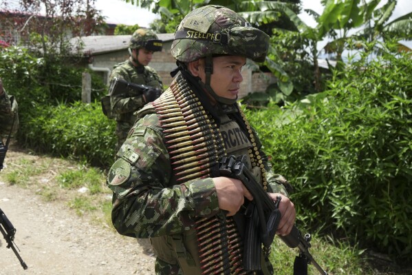 Soldiers patrol on the outskirts of Morales, Colombia, after an attack, Monday, May 20, 2024. According to police, two officers died in the attack by dissidents of the Revolutionary Armed Forces of Colombia (FARC) known as FARC-EMC. (AP Photo/Juan B Diaz)