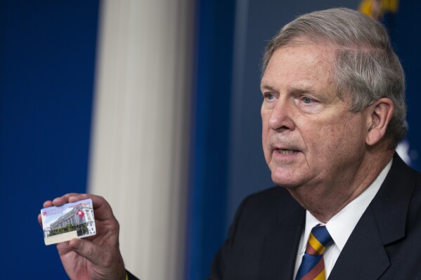 FILE - Agriculture Secretary Tom Vilsack holds up a Supplemental Nutrition Assistance Program Electronic Benefits Transfer (SNĢӰԺ EBT) card during a news conference at the White House, Wednesday, May 5, 2021, in Washington. Student and legal advocacy groups are petitioning the U.S. Department of Agriculture to lift the interview requirement for Supplemental Nutrition Assistance Program (SNĢӰԺ) applicants to receive food aid. (ĢӰԺ Photo/Evan Vucci, File)