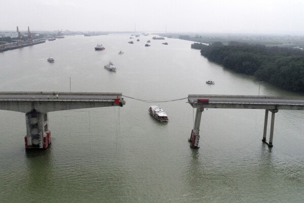 In this photo released by Xinhua News Agency, ships sail near broken Lixinsha Bridge in Nansha District of Guangzhou, south China's Guangdong Province, Thursday, Feb. 22, 2024. Few people are dead and missing after a massive container ship crashed into the bridge south of the city of Guangzhou in southern China early Thursday, causing a section of the bridge to come crashing down along with vehicles. (Lu Hanxin/Xinhua via AP)