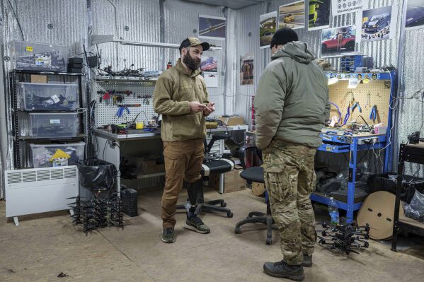 Pavlo Romanovskyi, chief of a Ukrainian drone laboratory who lost a leg in battle, talks to a fellow soldier in Ukraine's Kharkiv region on Feb. 12, 2025. (AP Photo/Evgeniy Maloletka)