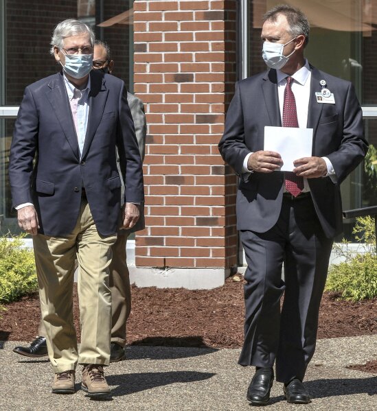 FILE - In this July 14, 2020, file photo Senate Majority Leader Mitch McConnell of Ky., left, walks with Ed Heath, CEO of Owensboro Health Muhlenberg Community Hospital, before a press conference at the hospital in Greenville, Ky. “It’s not going to magically disappear,” said McConnell, during a visit to a hospital in his Kentucky home state to thank front-line workers. (Greg Eans/The Messenger-Inquirer via AP, File)