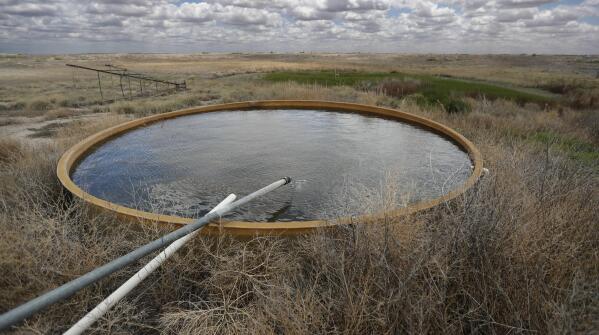 A natural spring fed by the Ogallala Aquifer fills a stock tank that provides water for wildlife at the Muleshoe National Wildlife Refuge outside Muleshoe, Texas, on Tuesday, May 18, 2021. The aquifer has become increasingly dry because of irrigation and drought. (AP Photo/Mark Rogers)