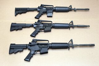 FILE - In this Aug. 15, 2012 file photo, three variations of the AR-15 rifle are displayed at the...