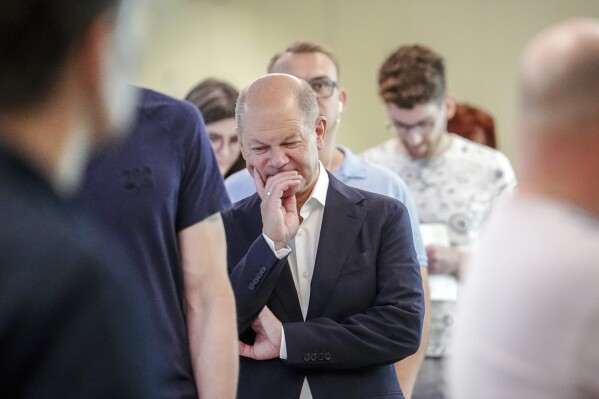 German Chancellor Olaf Scholz waits in line to cast his vote for the European Parliament elections, in Potsdam, Germany, Sunday, June 9, 2024. Tens of millions across the European Union were voting in EU parliamentary elections on Sunday in a massive exercise of democracy that is expected to shift the bloc to the right and redirect its future. (Kay Nietfeld/dpa via AP)