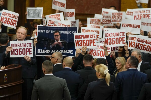 Opposition lawmakers hold banners reading: "Stole the elections" during a Serbia's parliament constitutive session in Belgrade, Serbia, Tuesday, Feb. 6, 2024. Serbia's National Assembly held an inaugural session on Tuesday as ruling nationalists ignored widespread reports that parliamentary and municipal elections held in December were marred by vote rigging and other irregularities. (AP Photo/Darko Vojinovic)