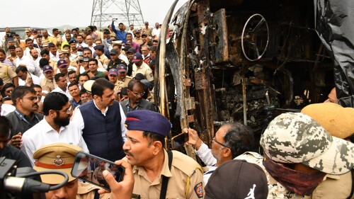 This photo provided by Maharashtra state Chief Minister's Office shows chief Minister Eknath Shinde, front in white, and Deputy chief Minister Devendra Fadnavis visit the site of a bus accident in Buldhana district of Maharashtra state, India, Saturday, July 1, 2023. A tire blowout caused the bus to lose control and crash into a road divider and burst into flames, killing 25 people early Saturday, police told local media.  (Maharashtra state Chief Minister's Office via AP)