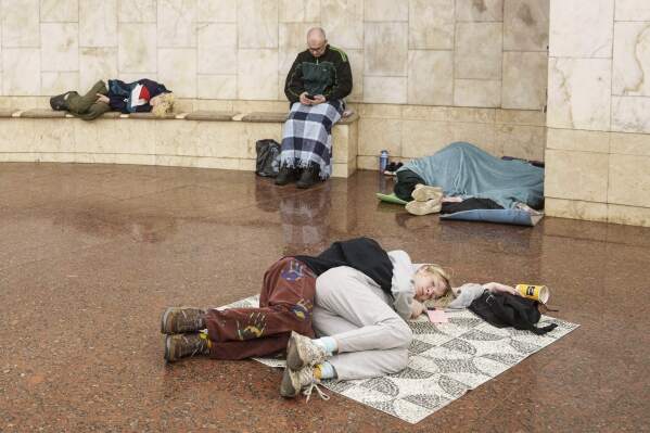 Couple sleeps on the floor while covered by metro stations during a Russian drone strike in Kiev, Ukraine on Tuesday, June 10th, 2025 (AP Photo/evgeniy Maloletka)