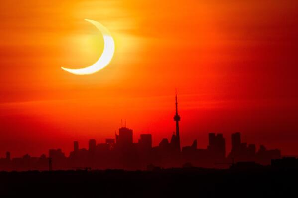 An annular solar eclipse rises over the skyline of Toronto on Thursday, June 10, 2021.  (Frank Gunn/The Canadian Press via AP)