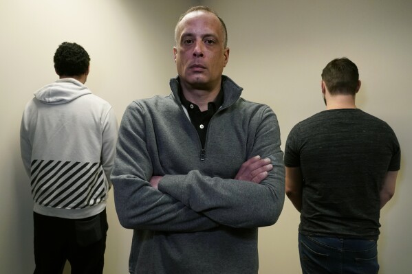 FILE - David Meehan, center, the lead plaintiff in a class-action lawsuit accusing the State of New Hampshire of covering up decades of sexual, physical and emotional abuse at its youth detention center, poses with two other victims who did not want to be identified, at his lawyer's office on Feb. 18, 2021, in Portsmouth, N.H. Lawyers representing 1,400 men and woman who allege they were abused as children at New Hampshire’s youth detention centers said Tuesday, Feb. 20, 2024, they will recommend the state’s out-of-court settlement option for most of their clients if lawmakers approve a plan to greatly expand its scope (AP Photo/Charles Krupa, File)