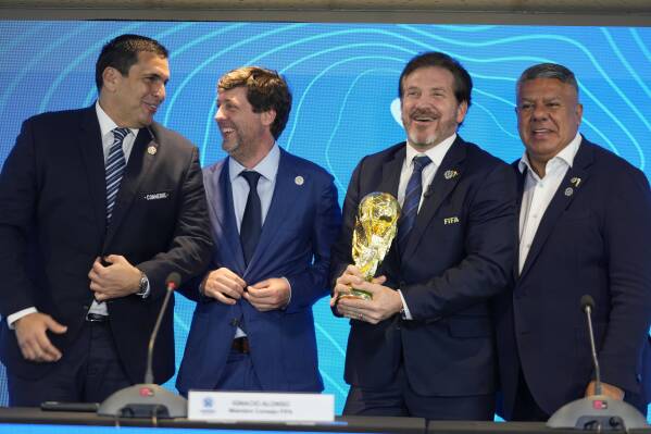 Paraguay's Soccer Association President Robert Harrison, left, FIFA delegate Ignacio Alonso, center, Conmebol President Alejandro Dominguez, third from left, and Conmebol Vice President Claudio Tapia stand after announcing host countries for the World Cup soccer tournament in Luque, Paraguay, Wednesday, Oct. 4, 2023. Some of the World Cup 2030 soccer tournament matches will be played in Argentina, Uruguay and Paraguay. (AP Photo/Jorge Saenz)
