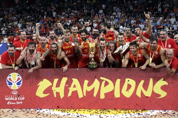 FILE - Members of Spain's team celebrate with the Naismith Trophy after they beat Argentina in their first-place match in the FIBA Basketball World Cup at the Cadillac Arena in Beijing, Sunday, Sept. 15, 2019. The Basketball World Cup is 32 teams playing for the biggest prize the international game has outside of Olympic gold. (AP Photo/Mark Schiefelbein, File)