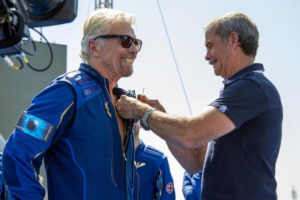 Virgin Galactic founder Richard Branson, left, receives a Virgin Galactic made astronaut wings pin from Canadian astronaut Chris Hadfield after his flight to space from Spaceport America near Truth or Consequences, N.M., Sunday, July 11, 2021. (AP Photo/Andres Leighton)