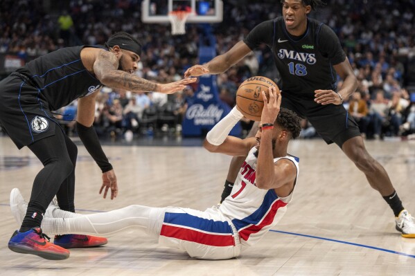 Detroit Pistons forward Troy Brown Jr. (7) looks to pass the ball as Dallas Mavericks guard Jaden Hardy, left, and forward Olivier-Maxence Prosper (18) defend during the second half of an NBA basketball game Friday, April 12, 2024, in Dallas. (AP Photo/Jeffrey McWhorter)