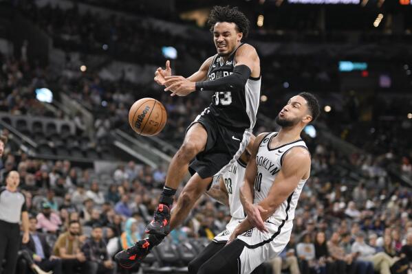 San Antonio Spurs' Tre Jones (33) loses the ball as he collides with Brooklyn Nets' Ben Simmons during the second half of an NBA basketball game Tuesday, Jan. 17, 2023, in San Antonio. (AP Photo/Darren Abate)