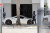 A man walks past a Ferrari in the driveway at Sean Kingston's home in the suburb of Southwest Ranches, Fla., Thursday, May 23, 2024. A SWAT team raided rapper Kingston's rented mansion on Thursday, and arrested his mother on fraud and theft charges that an attorney says stems partly from the installation of a massive TV at the home. Broward County detectives arrested Janice Turner, 61, at the home. (Amy Beth Bennett/South Florida Sun-Sentinel via AP)