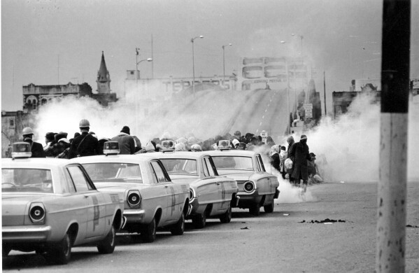 FILE - Tear gas fills the air as state troopers, ordered by Alabama Gov. George Wallace, break up a march at the Edmund Pettus Bridge in Selma, Ala., March 7, 1965, on what became known as Bloody Sunday. (AP Photo, File)