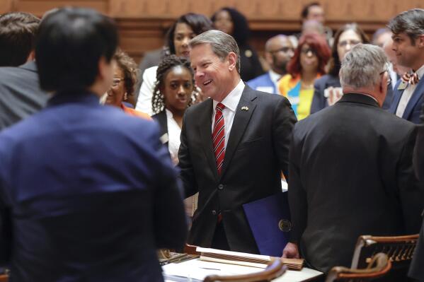 FILE - Georgia Gov. Brian Kemp greets legislators as he enters the House chambers on Sine Die, the last day of the General Assembly at the Georgia state Capitol in Atlanta, Wednesday, March 29, 2023. On Tuesday, April 4, Kemp vetoed a bill that would have capped tuition increases at public universities and colleges, calling it an infringement on the authority of the state Board of Regents and a violation of the state constitution. (Natrice Miller/Atlanta Journal-Constitution via AP, File)