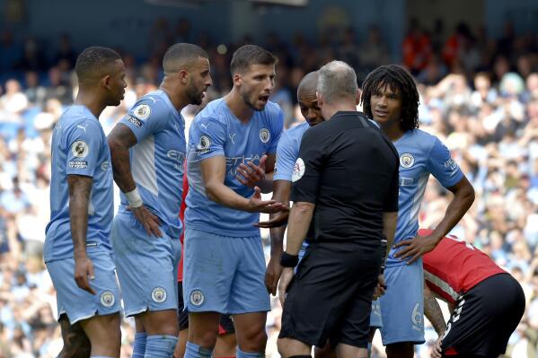 Manchester City players argue with referee Jonathan Moss who then went to watch a VAR replay before reversing his decision to give a penalty and a red card to Manchester City's Kyle Walker, second left, during the English Premier League soccer match between Manchester City and Southampton at the Etihad Stadium in Manchester, England, Saturday, Sept. 18, 2021. (AP Photo/Rui Vieira)