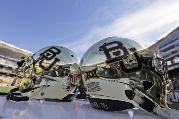 FILE - Baylor helmets rest on the field after an NCAA college football game in Waco, Texas, Dec. 5, 2015. Baylor University has settled a years-long federal lawsuit brought by 15 women who alleged they were sexually assaulted at the nation’s largest Baptist school. (AP Photo/LM Otero, File)