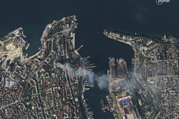 In this satellite photo provided by Planet Labs, smoke billows from a headquarters building for the Russian Black Sea fleet in Sevastopol, Crimea on Friday, Sept. 22, 2023, after it was struck in a missile attack launched by the Ukrainian military. (Planet Labs via AP)