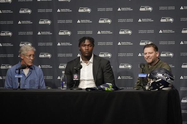 Seattle Seahawks first-round NFL football draft pick Charles Cross, center, an offensive tackle from Mississippi State, talks to reporters with Seahawks head coach Pete Carroll, left, and general manager John Schneider, right, Friday, April 29, 2022, at the team's headquarters in Renton, Wash. (AP Photo/Ted S. Warren)