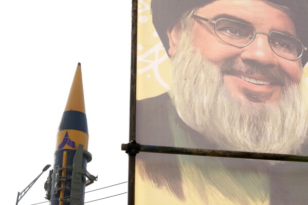An Iranian domestically built missile is displayed in front of the portrait of the Lebanese Hezbollah leader Sayyed Hassan Nasrallah during a rally of Iran's Basij paramilitary force in support of the Palestinians in Tehran, Iran, Friday, Nov. 24, 2023. (AP Photo/Vahid Salemi)