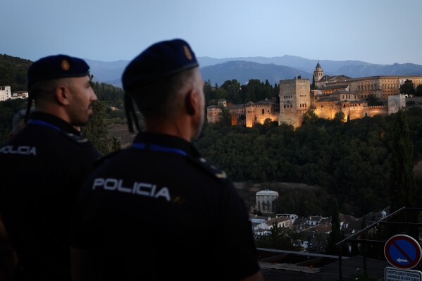 Two police officers stand guard at San Nicolas viewpoint overlooking the Alhambra where European leaders are gathering, in southern Spain's Granada, Thursday, Oct. 5, 2023. Almost 50 European leaders are using a summit in southern Spain's Granada to stress they stand by Ukraine at a time when Western resolve appears somewhat weakened. (AP Photo/Fermin Rodriguez)