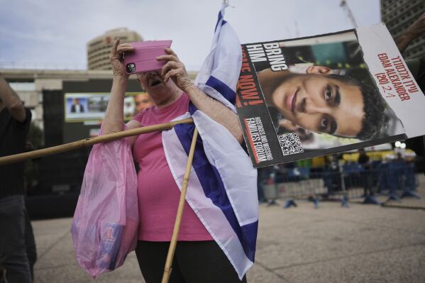 A man holds a placard of Israeli-American soldier Edan Alexander as he waits for his release from Hamas captivity in Gaza, at a plaza known as the hostages square in Tel Aviv, Monday, May 12, 2025. Alexander was abducted during the Hamas-led attack on his base on October 7, 2023. (AP Photo/Oded Balilty)