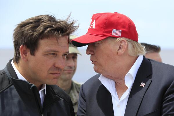 FILE - President Donald Trump talks to Florida Gov. Ron DeSantis, left, during a visit to Lake Okeechobee and Herbert Hoover Dike at Canal Point, Fla., March 29, 2019. Republican 2024 presidential prospects descend upon Las Vegas this weekend as anxious donors and activists openly consider whether to embrace former President Donald Trump for a third consecutive run for president. Trump will be among the only major Republican prospects not in attendance for the Republican Jewish Coalition’s annual leadership meeting. (AP Photo/Manuel Balce Ceneta, File)