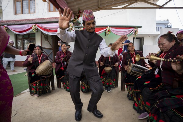 A guest dances as members of Shrijanshil Mahila Sanstha, or the Self-Reliant Women’s Group, play at a wedding in Kathmandu, Nepal, Wednesday, March 6, 2024. (AP Photo/Niranjan Shrestha)