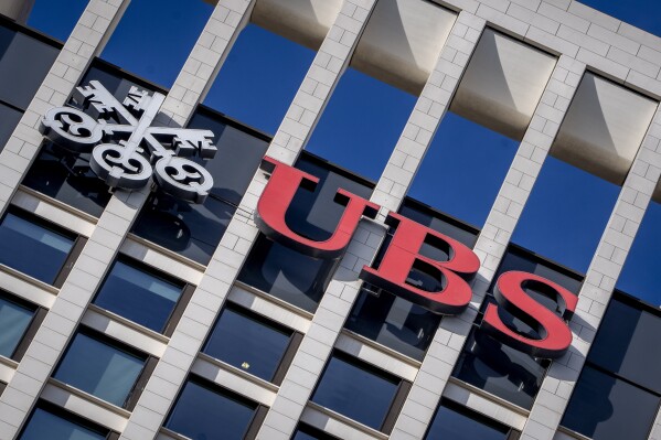 FILE - The logo of Swiss bank UBS is fixed on a building where the bank has offices in Frankfurt, Germany, Nov. 8, 2022. Swiss banking giant UBS will pay nearly $400 million in fines to U.S., Swiss and U.K. banking authorities for the management failures of Credit Suisse, which UBS bought in June 2023, related to how Credit Suisse handled its relationship with collapsed hedge fund Archegos Capital Management. (AP Photo/Michael Probst, File)
