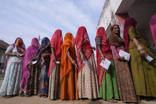FILE- Women stand in a queue to cast their votes in Chachiyawas village, near Ajmer, India, Nov. 25, 2023. India’s top court on Thursday struck down a controversial election funding system that allowed individuals and companies to send unlimited donations to political parties without any need to disclose donor identity, a system critics have long said is undemocratic and favored Prime Minister Narendra Modi's ruling party. (AP Photo/ Deepak Sharma, File)