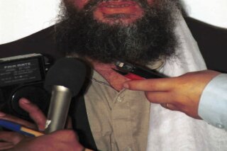 FILE - In this in this 1998 file photo made available Friday, March 19, 2004, Ayman al-Zawahri speaks to the press in Khost, Afghanistan. On Wednesday, Sept, 11, 2019, Al-Qaeda leader al-Zawahri called on all Muslims to attack U.S., European, Israeli and Russian targets in a speech on the 18th anniversary of the 9/11 terror attacks. SITE Intelligence Group reports that in a video released by the militant group, al-Zawahri  also criticized "backtrackers" from jihad. (AP Photo/Mazhar Ali Khan, File)