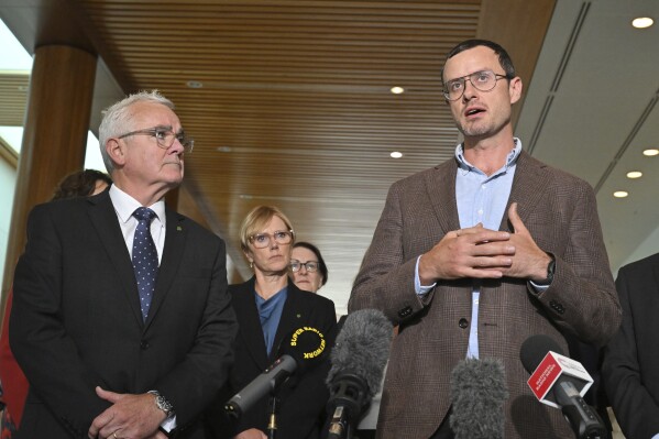 Independent member of parliament Andrew Wilkie, left, and Julian Assange's brother Gabriel Shipton, right, speak to the media at Parliament House in Canberra, Thursday, Feb. 15, 2024. Australia's House of Representatives has passed a motion calling on the United States and the UK to end the prosecution of WikiLeaks founder Julian Assange and for him to be allowed to return to his home country. (Mick Tsikas/AAP Image via AP)