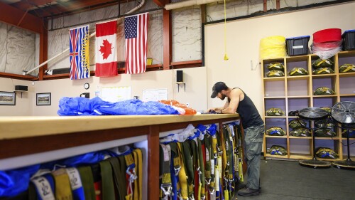U.S. Forest Service smokejumper Kevin Schmitz rigs a parachute on Saturday, July 1, 2023, in Fort St. John, British Columbia. Schmitz is one of approximately a hundred American smokejumpers, firefighters who parachute into remote wildfires, working alongside their Canadian counterparts at the Fort St. John base, according to Wildfire Officer James Bergen. (AP Photo/Noah Berger)