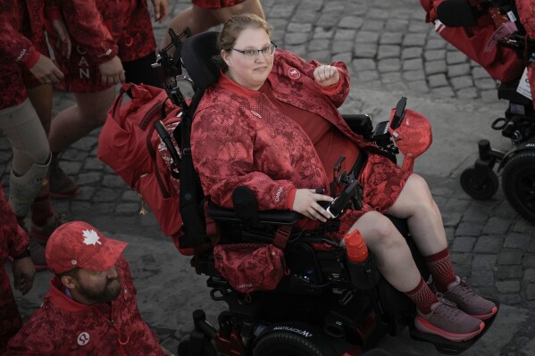 FILE - Alison Levine, a Paralympian who competes in the sport of boccia, parades with fellow athletes in the Paralympics Opening Ceremony from Team Canada in Paris, Wednesday Aug. 28, 2024. Levine and teammates are dressed in uniforms designed by Lululemon with adaptive fashion in mind. (AP Photo/Aurelien Morissard, File)