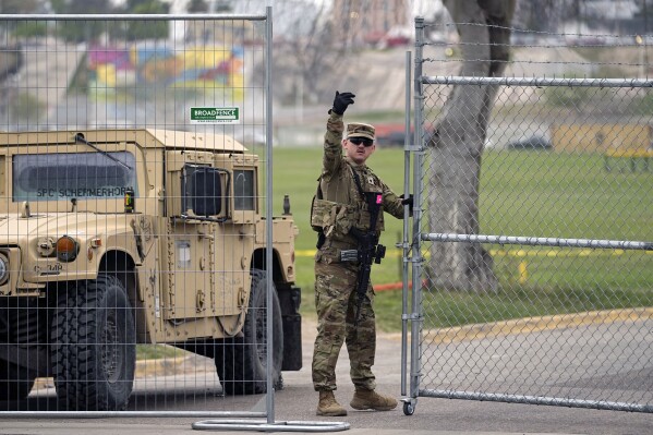 A member of the National Guard directs a vehicle at the gate to Shelby Park along the Rio Grande, Wednesday, Feb. 28, 2024, in Eagle Pass, Texas. Republican presidential candidate former President Donald Trump is scheduled to visit the area Thursday. (AP Photo/Eric Gay)