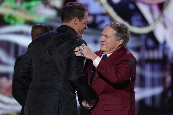 Coach Bill Belichick hugs and presents the AP Coach of the year award to Minnesota Vikings coach Kevin O'Connell during the NFL Honors award show ahead of the Super Bowl 59 football game, Thursday, Feb. 6, 2025, in New Orleans. (AP Photo/David J. Phillip)