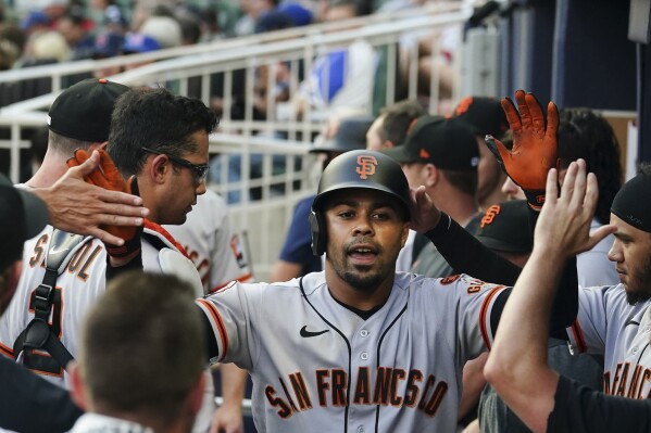 San Francisco Giants' LaMonte Wade Jr. (31) celebrates in the dugout after hitting a home run in the first inning of the team'ss baseball game against the Atlanta Braves on Saturday, Aug. 19, 2023, in Atlanta. (AP Photo/John Bazemore)